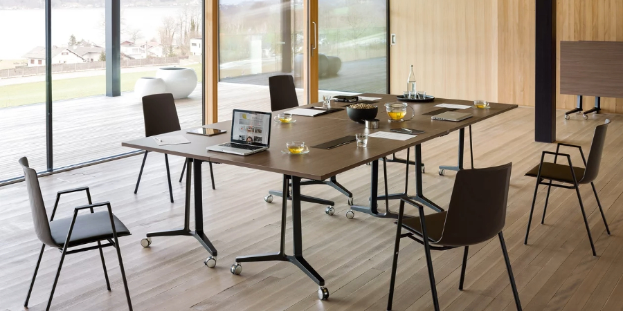 Offenes Büro mit Schreibtischen in schwarz mit Beistellstühlen in schwarz mit Armlehnen.